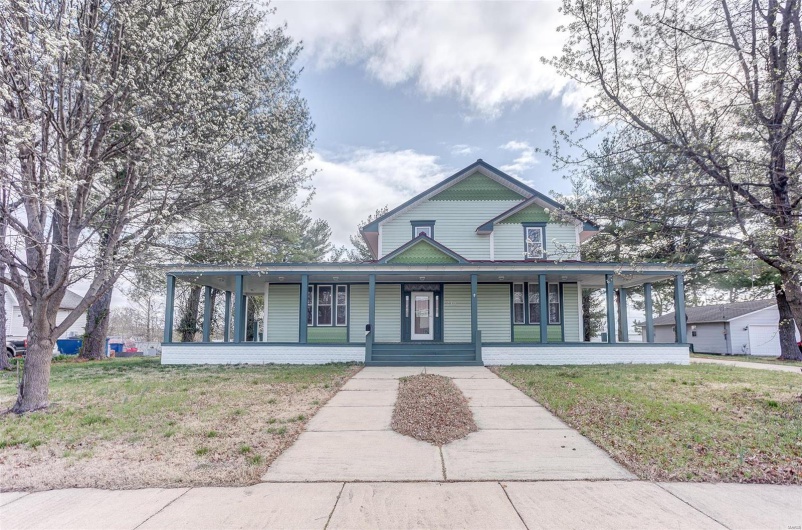 Farmhouse-style home featuring a porch and a front lawn