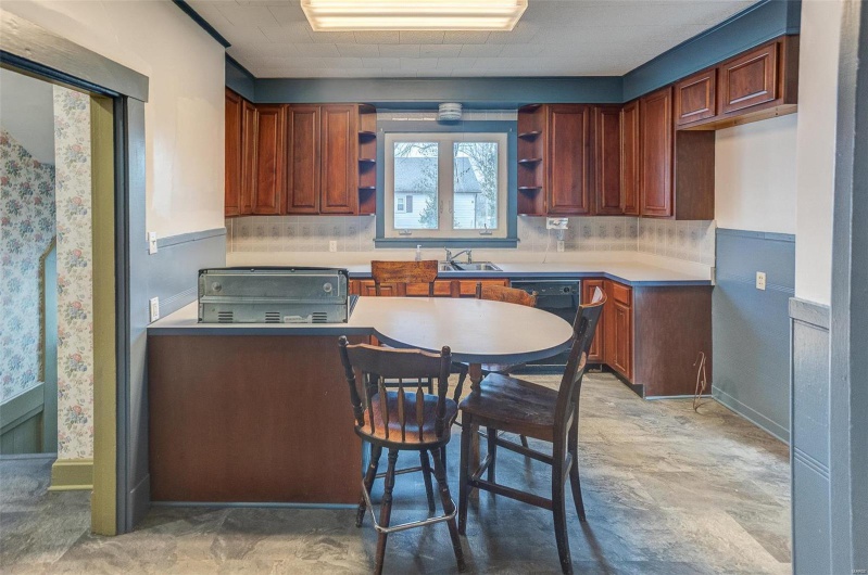 Kitchen featuring a sink, open shelves, black dishwasher, and tasteful backsplash