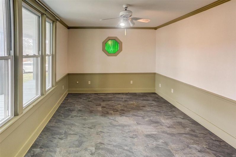 Unfurnished room with plenty of natural light, wainscoting, ceiling fan, and ornamental molding