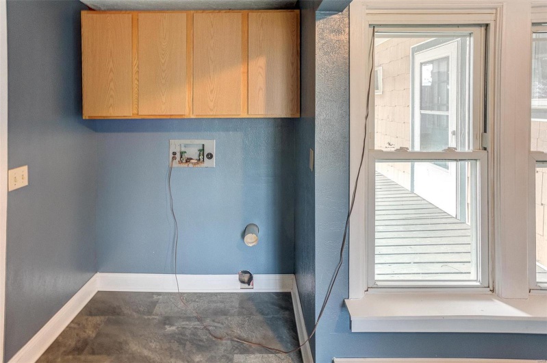 Clothes washing area featuring cabinet space, hookup for a washing machine, and baseboards