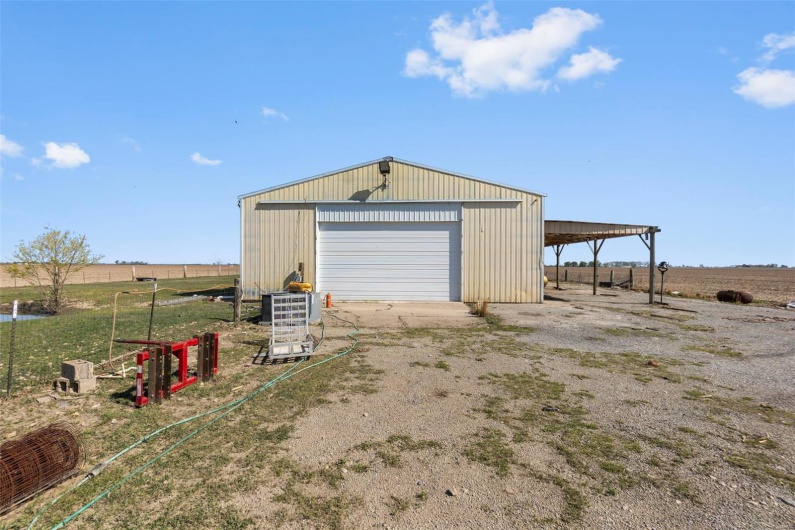 Garage with a garage, dirt driveway, and a rural view