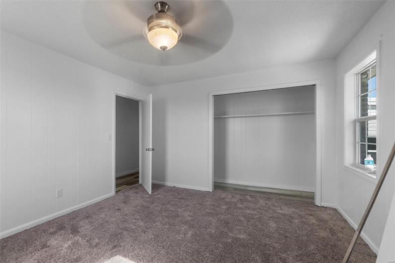 Unfurnished bedroom with carpet, a closet, baseboards, and ceiling fan
