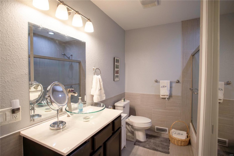 Full bath featuring tile walls, visible vents, and tiled shower