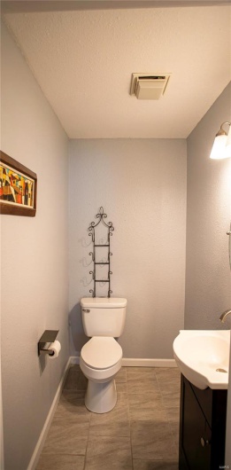 Bathroom featuring toilet, vanity, and visible vents