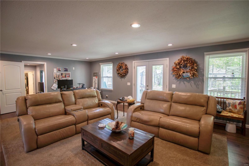 Living room featuring crown molding, a healthy amount of sunlight, wood finished floors, and recessed lighting