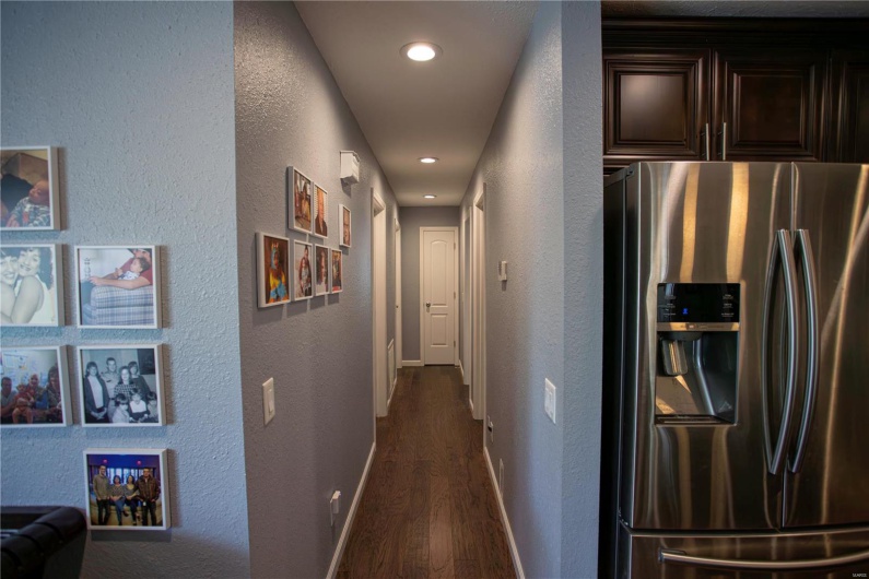 Hallway with a textured wall and dark wood-style floors