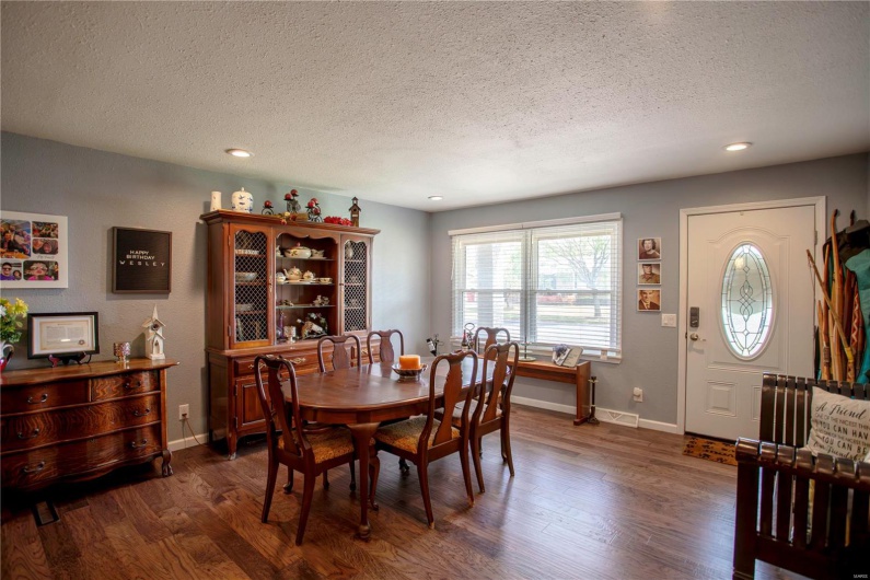 Dining space with dark wood-style flooring, a textured ceiling, and recessed lighting