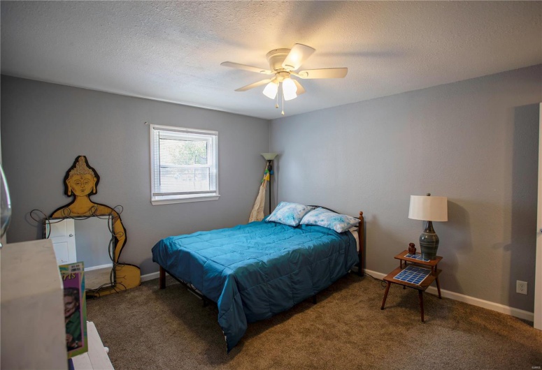 Bedroom featuring carpet, a ceiling fan, baseboards, and a textured ceiling