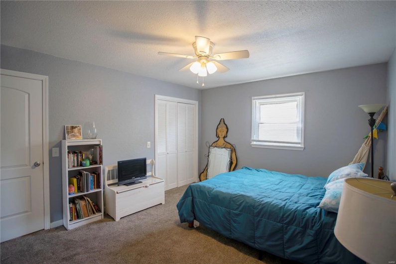 Bedroom featuring a textured ceiling, a closet, carpet flooring, and a ceiling fan