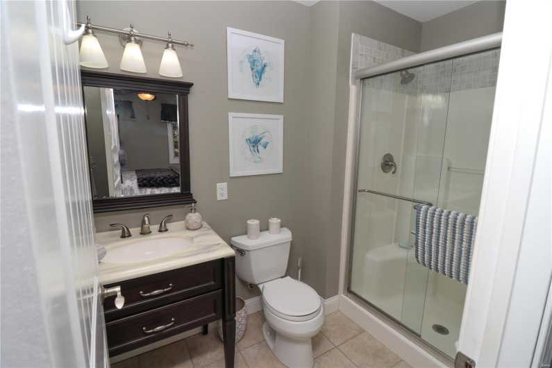 Full bathroom featuring vanity, toilet, a stall shower, and ensuite bathroom