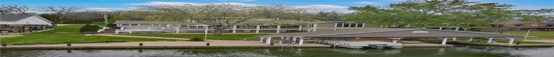 Residential For Sale View of dock featuring a lawn, a water view, boat lift, a residential view, and stairs