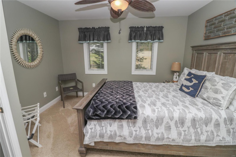 Bedroom featuring ceiling fan, baseboards, and carpet