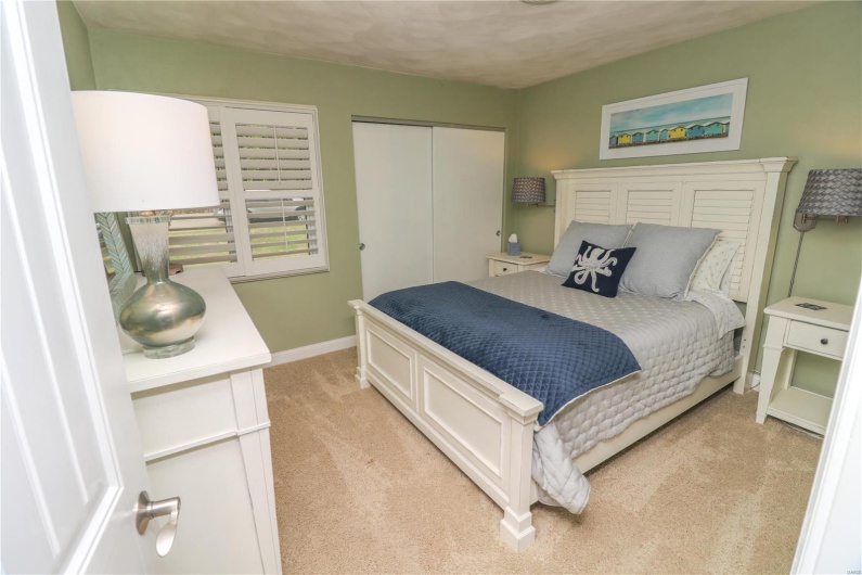 Bedroom featuring baseboards, light carpet, and a closet
