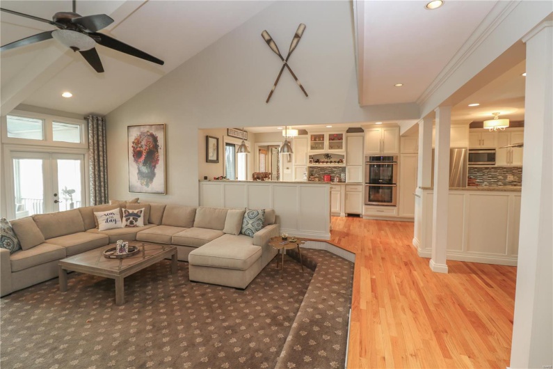 Living area with recessed lighting, a healthy amount of sunlight, light wood finished floors, and high vaulted ceiling