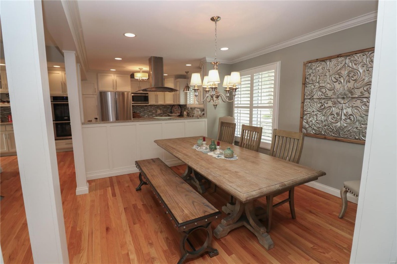 Dining room featuring baseboards, recessed lighting, light wood-style floors, a chandelier, and ornamental molding
