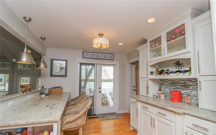 Kitchen with tasteful backsplash, open shelves, light wood-type flooring, white cabinetry, and recessed lighting
