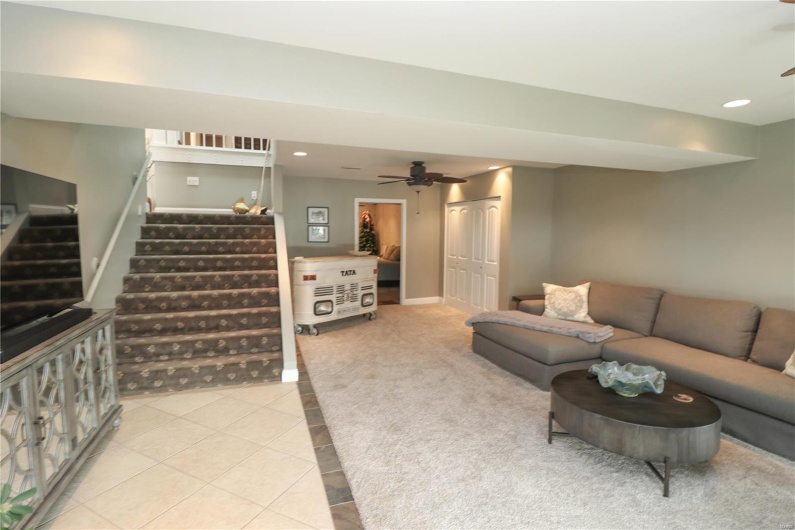 Tiled living room with a ceiling fan, baseboards, recessed lighting, and stairway