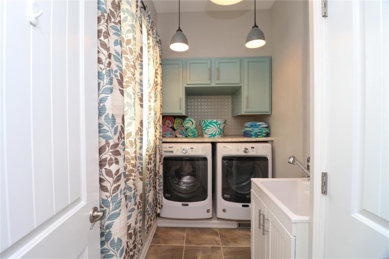 Washroom featuring tile patterned floors, washer and dryer, and cabinet space
