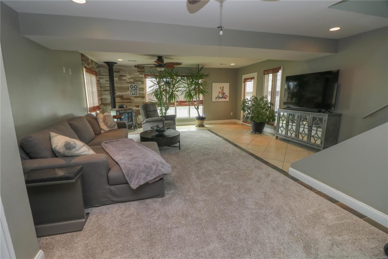 Living area featuring ceiling fan, baseboards, recessed lighting, and a wood stove