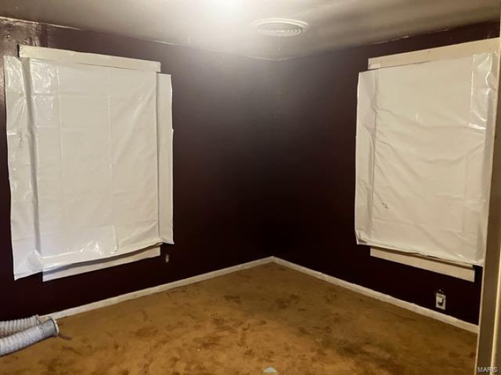 Carpeted spare room with baseboards