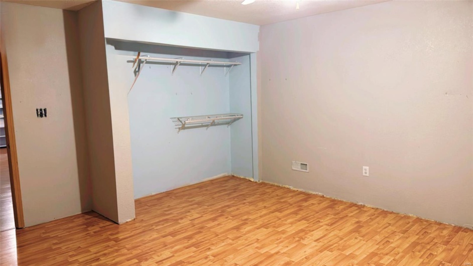 Unfurnished bedroom with wood finished floors and a closet