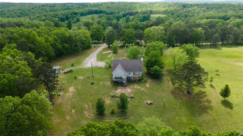 Overview of rural landscape featuring a heavily wooded area
