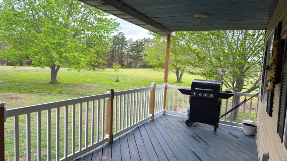 Deck with a lawn and a grill