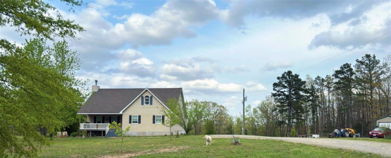 View of property exterior with a lawn, gravel driveway, and a chimney