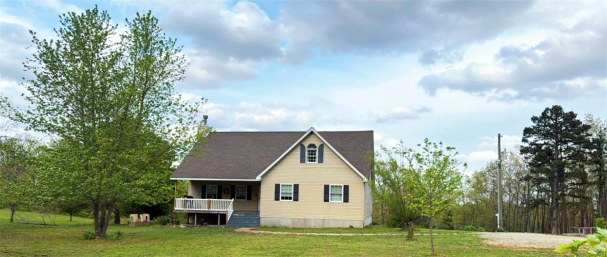 View of front facade with a front lawn and covered porch