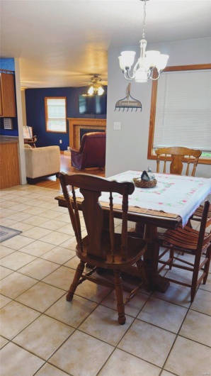 Dining area with a fireplace, a notable chandelier, and light tile patterned floors