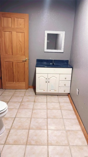 Bathroom featuring toilet, vanity, and tile patterned floors