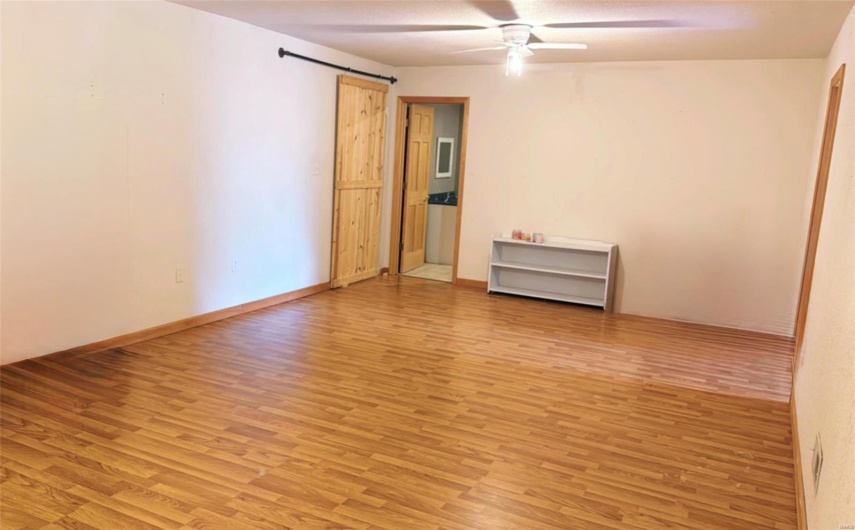Unfurnished room with light wood finished floors, baseboards, and a ceiling fan