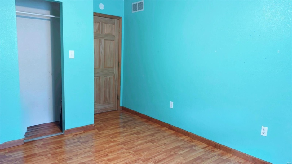 Unfurnished bedroom with baseboards, light wood finished floors, visible vents, and a closet