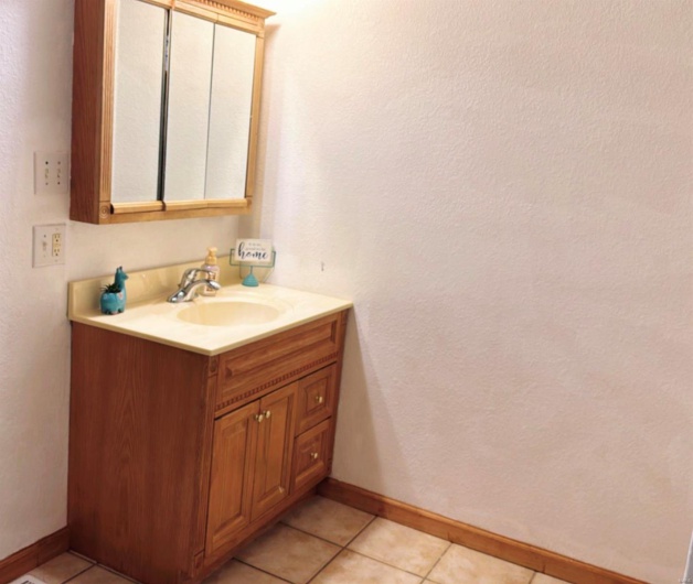 Bathroom with vanity, tile patterned flooring, and baseboards