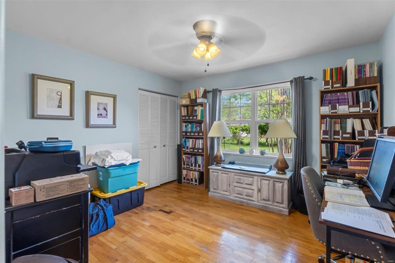 Office space with a ceiling fan and light wood-style flooring