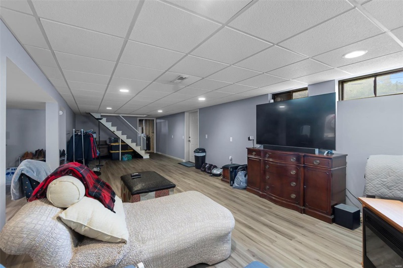 Living room featuring recessed lighting, wood finished floors, visible vents, and stairs