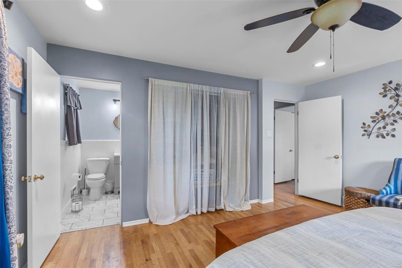 Bedroom with ensuite bath, wood finished floors, baseboards, and recessed lighting