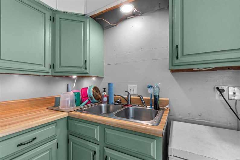 Kitchen with green cabinets and a sink