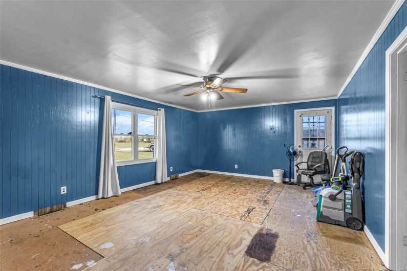 Unfurnished room featuring a ceiling fan, baseboards, and crown molding