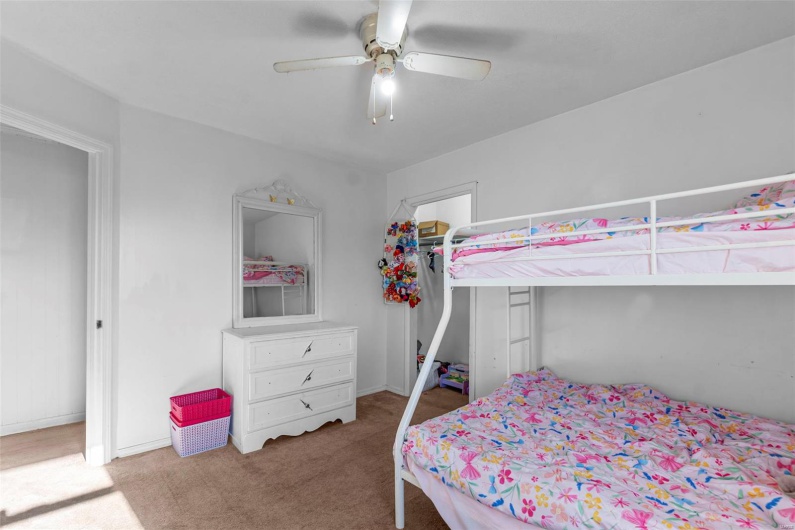 Carpeted bedroom featuring a ceiling fan, baseboards, and a closet