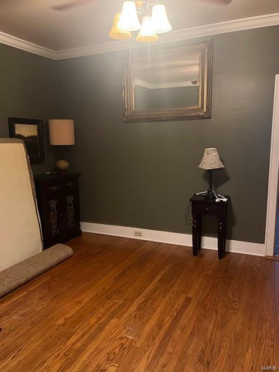 Unfurnished bedroom featuring ornamental molding and hardwood / wood-style flooring