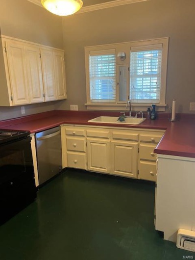 Kitchen with sink, dishwasher, white cabinets, and range