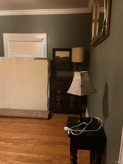Bedroom featuring crown molding and hardwood / wood-style floors
