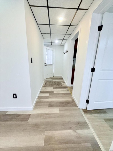Hallway leading to kitchen, bathroom, utility room and backdoor.