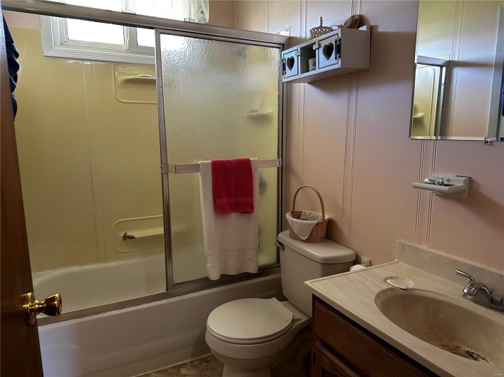 Full bathroom with shower / bath combination with glass door, vanity, and toilet