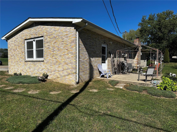 View of side of home featuring a patio and a yard