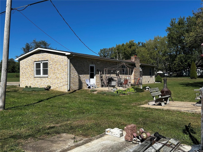 Back of house featuring a lawn and a patio