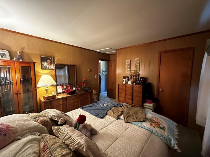 Bedroom featuring ornamental molding and wood walls
