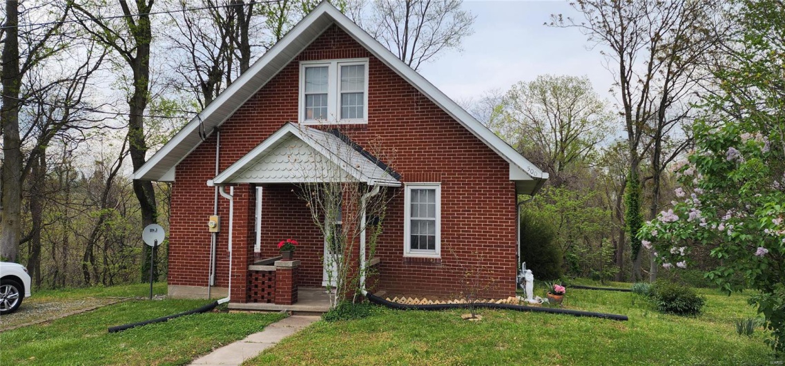 Bungalow-style home with a front lawn and brick siding