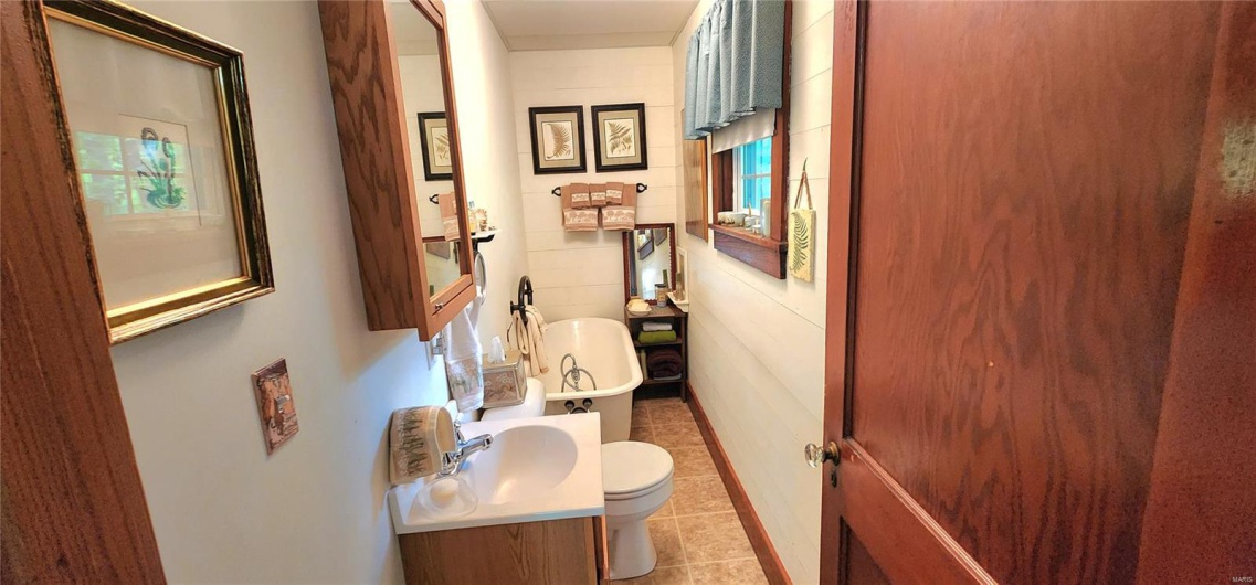 Bathroom featuring tile patterned flooring, a sink, and toilet